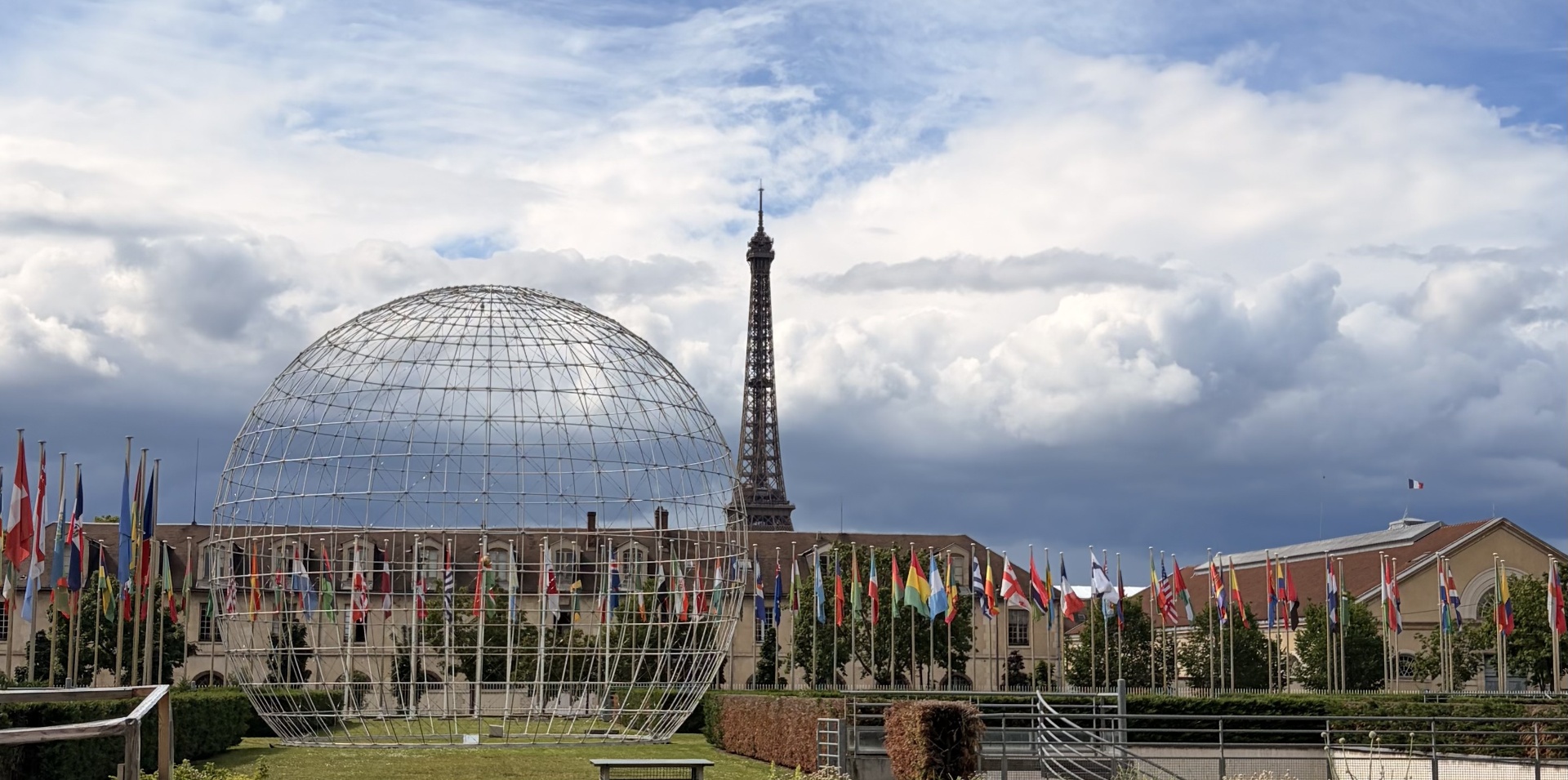 Globe sculpture and international flags in front of the Eiffel Tower, Paris